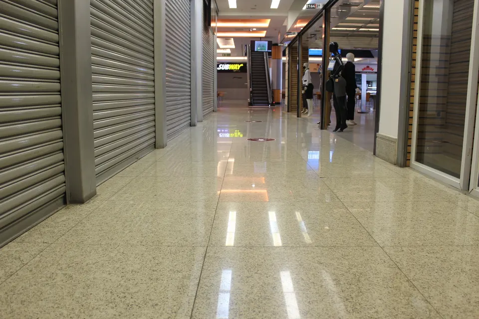 Corredor de lojas da Galeria Pagé Brás com piso em granito Branco Polar polido