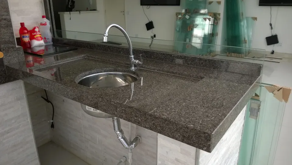 Bancada de churrasqueira em granito marrom com cuba redonda inox e torneira cromada com acabamento limpo — Granito Café Imperial