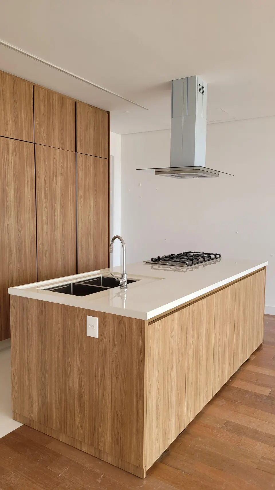 Bancada de cozinha em quartzo branco com cuba dupla embutida e torneira monocomando, ilha com cooktop, acabamento polido e brilhante