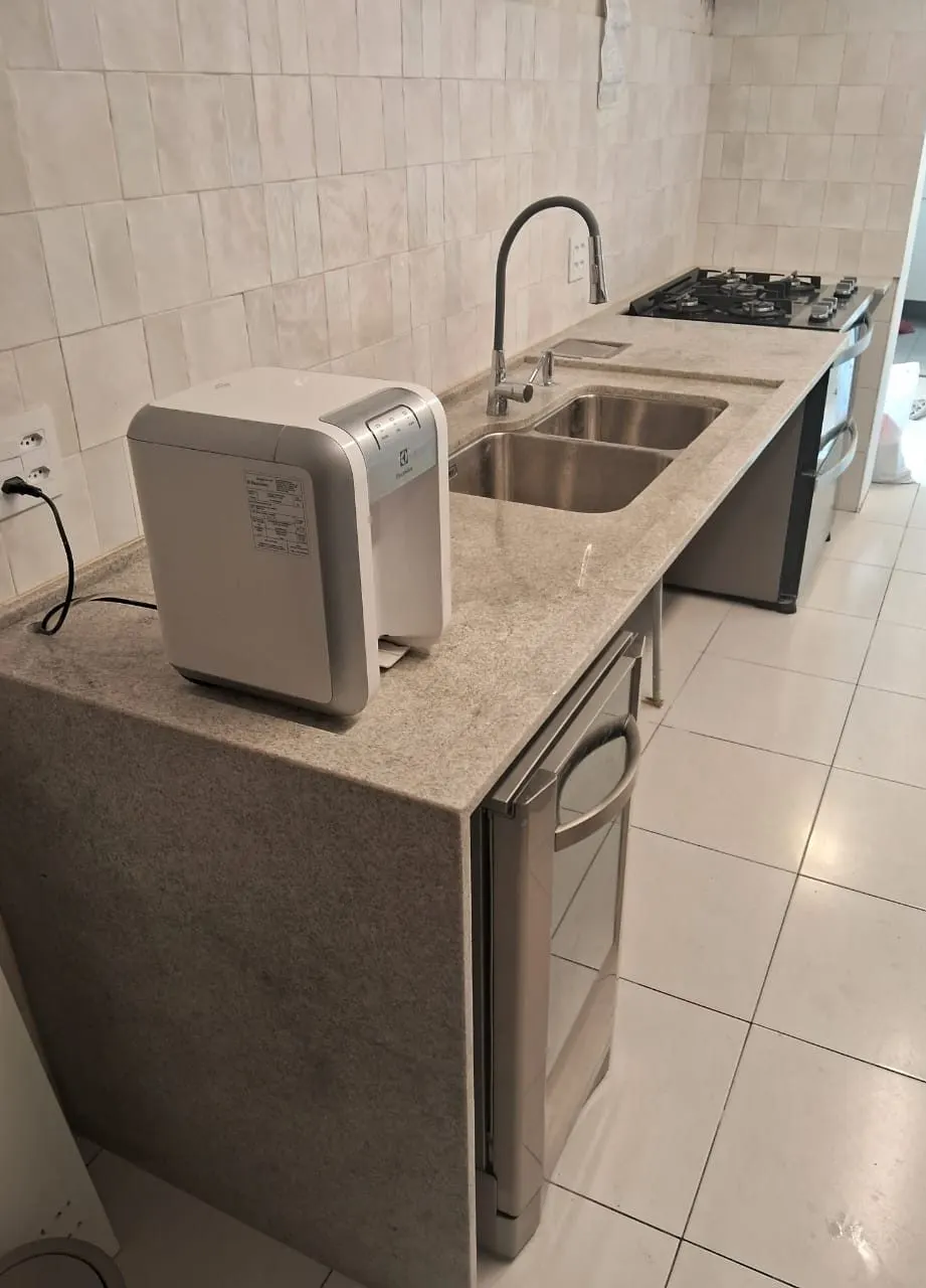 Bancada de cozinha em granito branco com cuba dupla em inox e torneira cromada, instalada com pé — Granito Branco Itaúnas