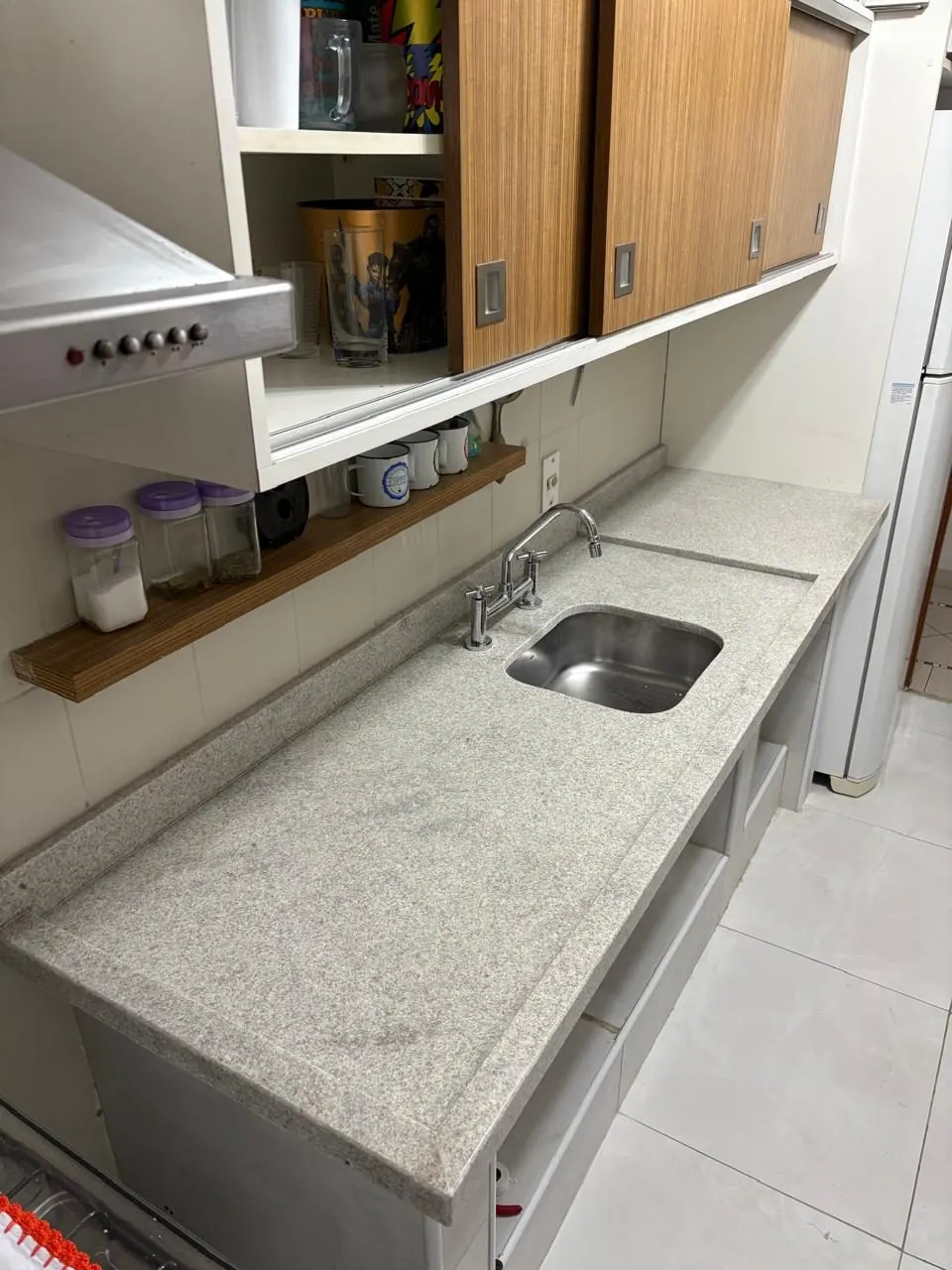 Bancada de cozinha em granito branco/cinza claro com cuba de aço inox embutida e nichos de madeira — Granito Branco Itaúnas