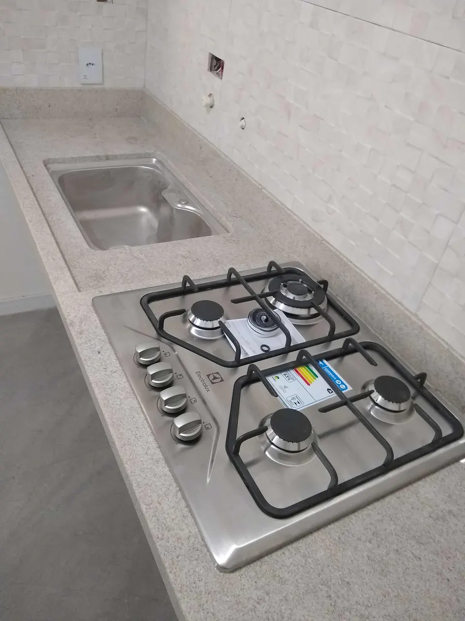 Bancada de cozinha em granito branco com cuba embutida e fogão cooktop instalado — Granito Branco Itaúnas