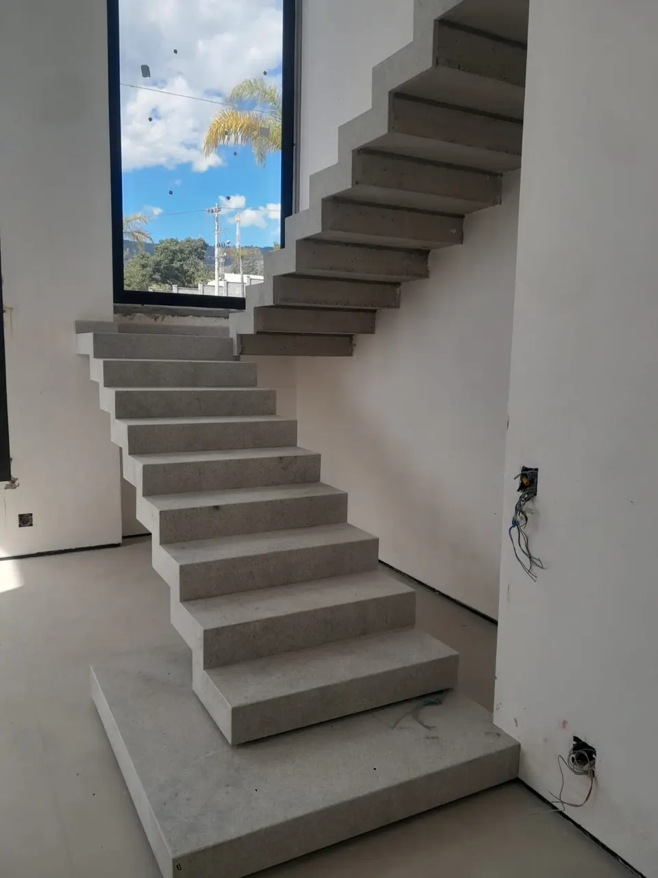 Escada em L com degraus em granito branco claro, acabamento uniforme, instalação em ambiente residencial com janela ao fundo — Granito Branco Itaúnas